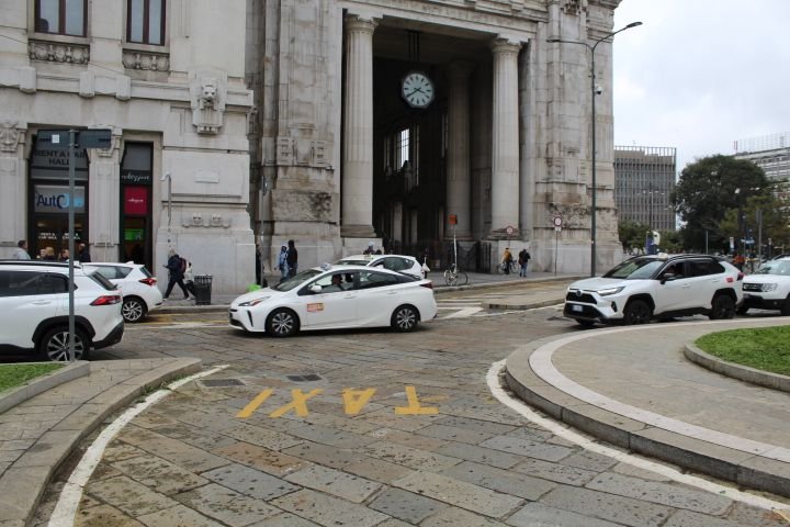 Des voitures taxis circulant dans la villde Milan Lombardie en Italie photo gratuite