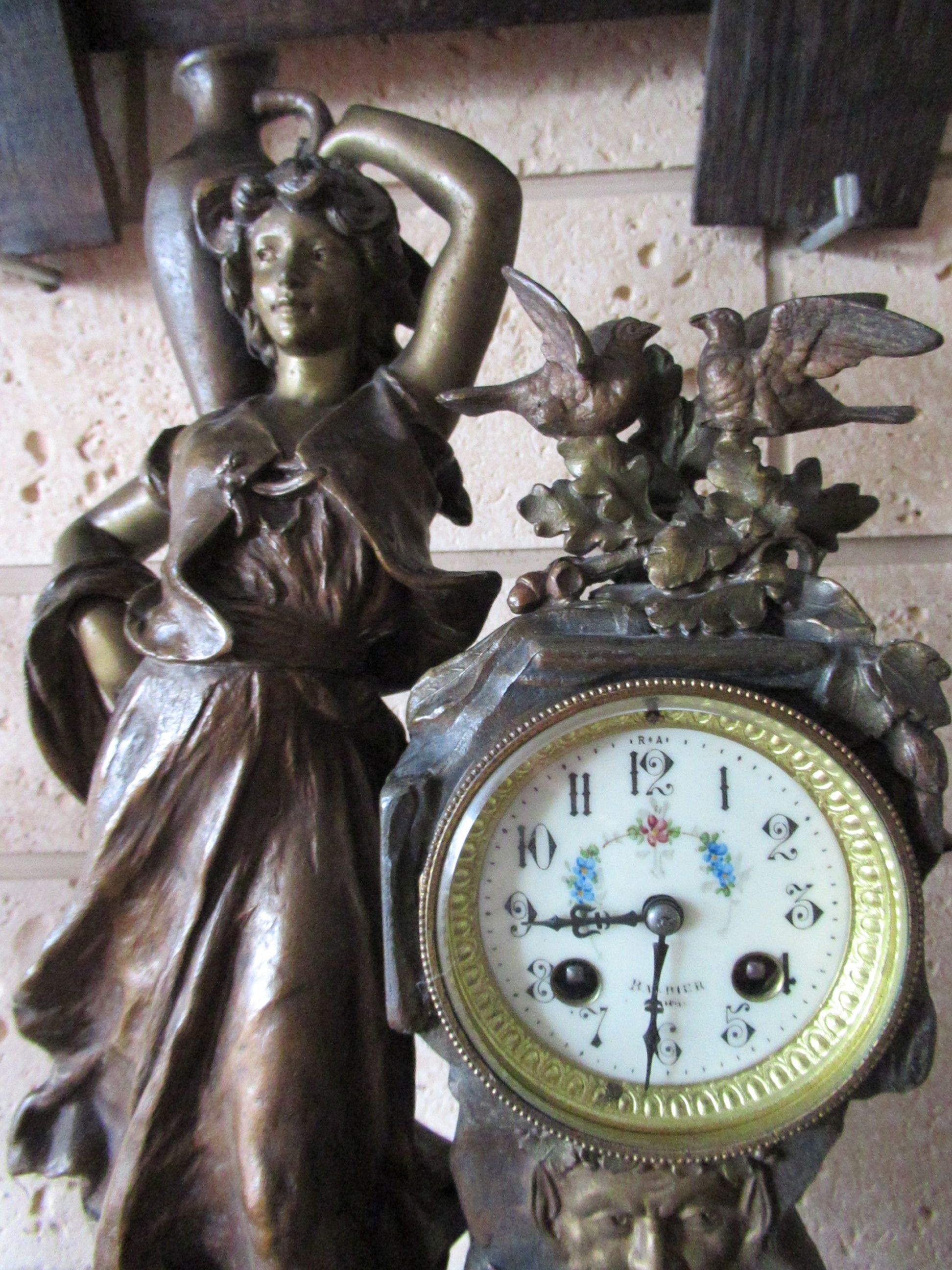 Pendule ancienne avec sculpture d'une statue de bronze