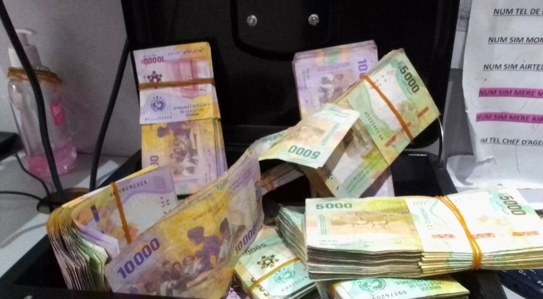 Liasses de billets en francs CFA dans une caisse photo gratuite
