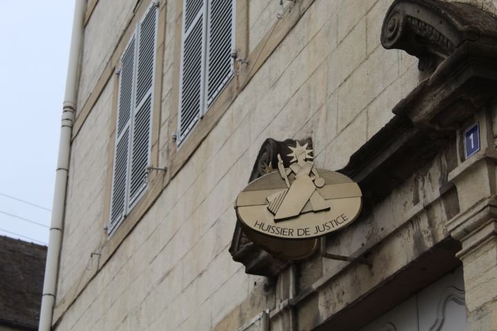 Plaque d'huissier de justice sur un bâtiment en pierre photo gratuite