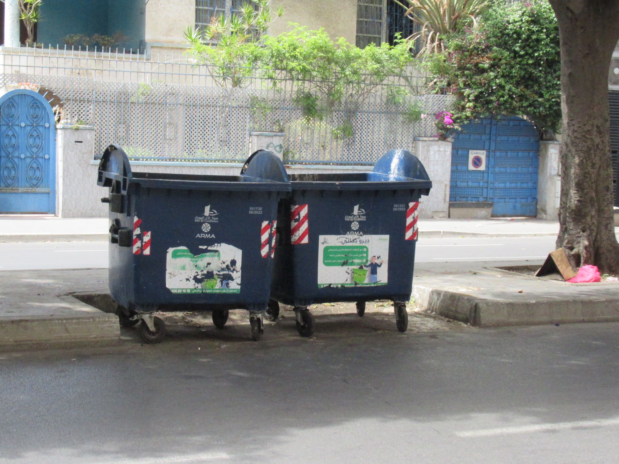 Deux bacs à ordures roulantes de couleur bleue dans une rue