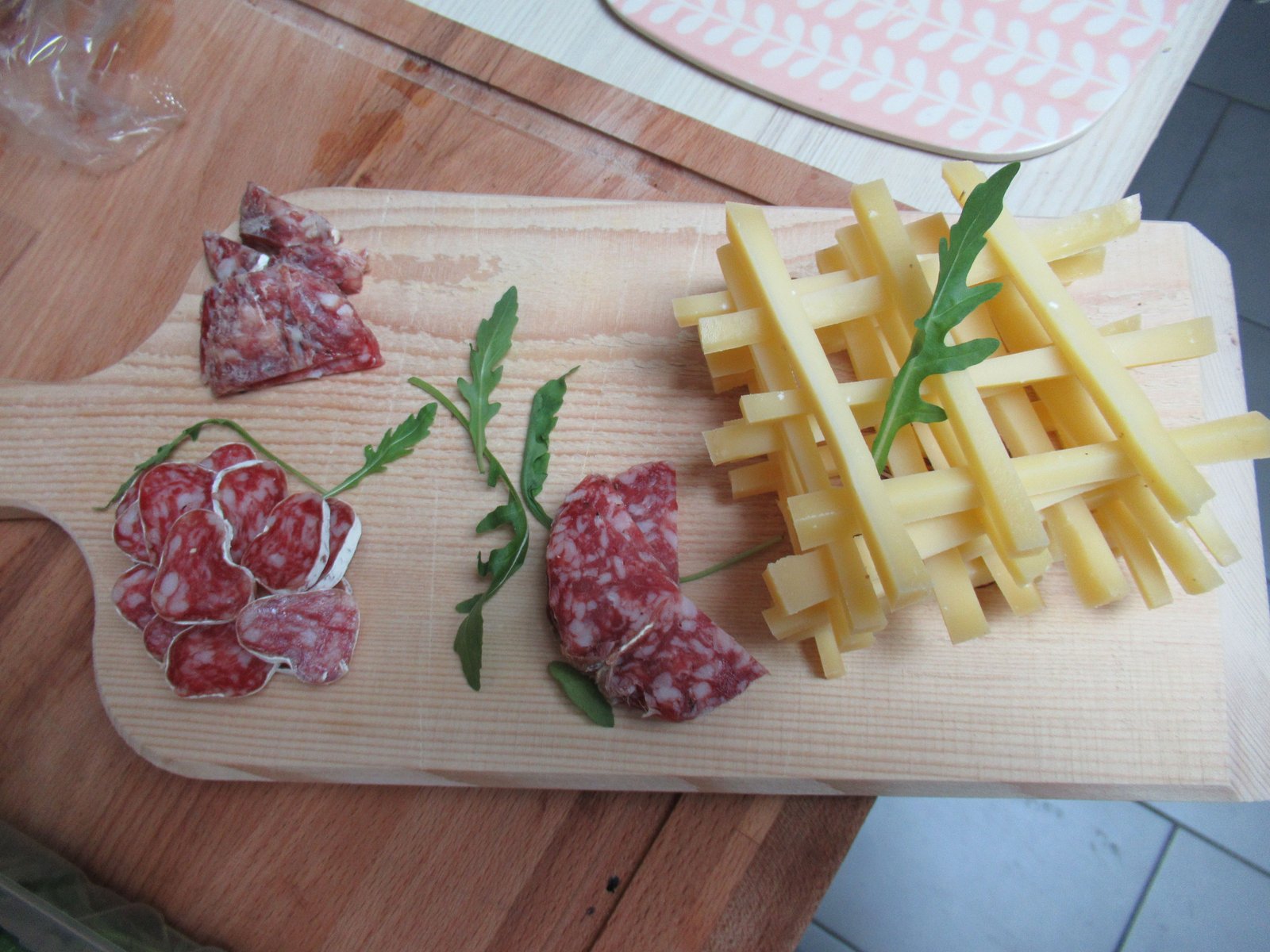 Tranches de saucisses sèches et bâtons de fromage sur une planche à découper