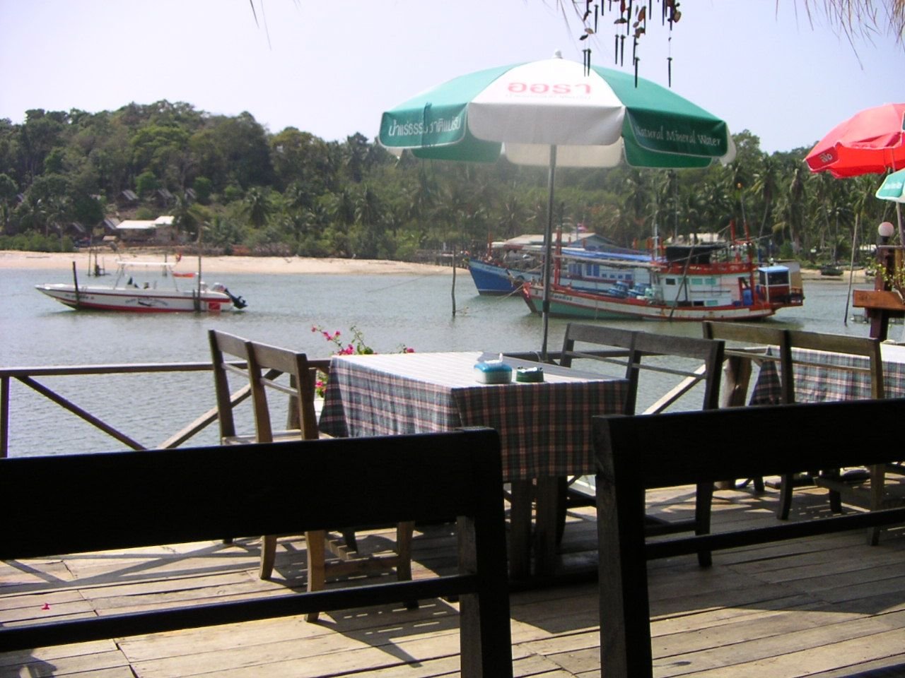 Un restaurant en bord de mer, situé en Thaïlande, avec une vue sur l'eau et des bateaux, photo gratuite