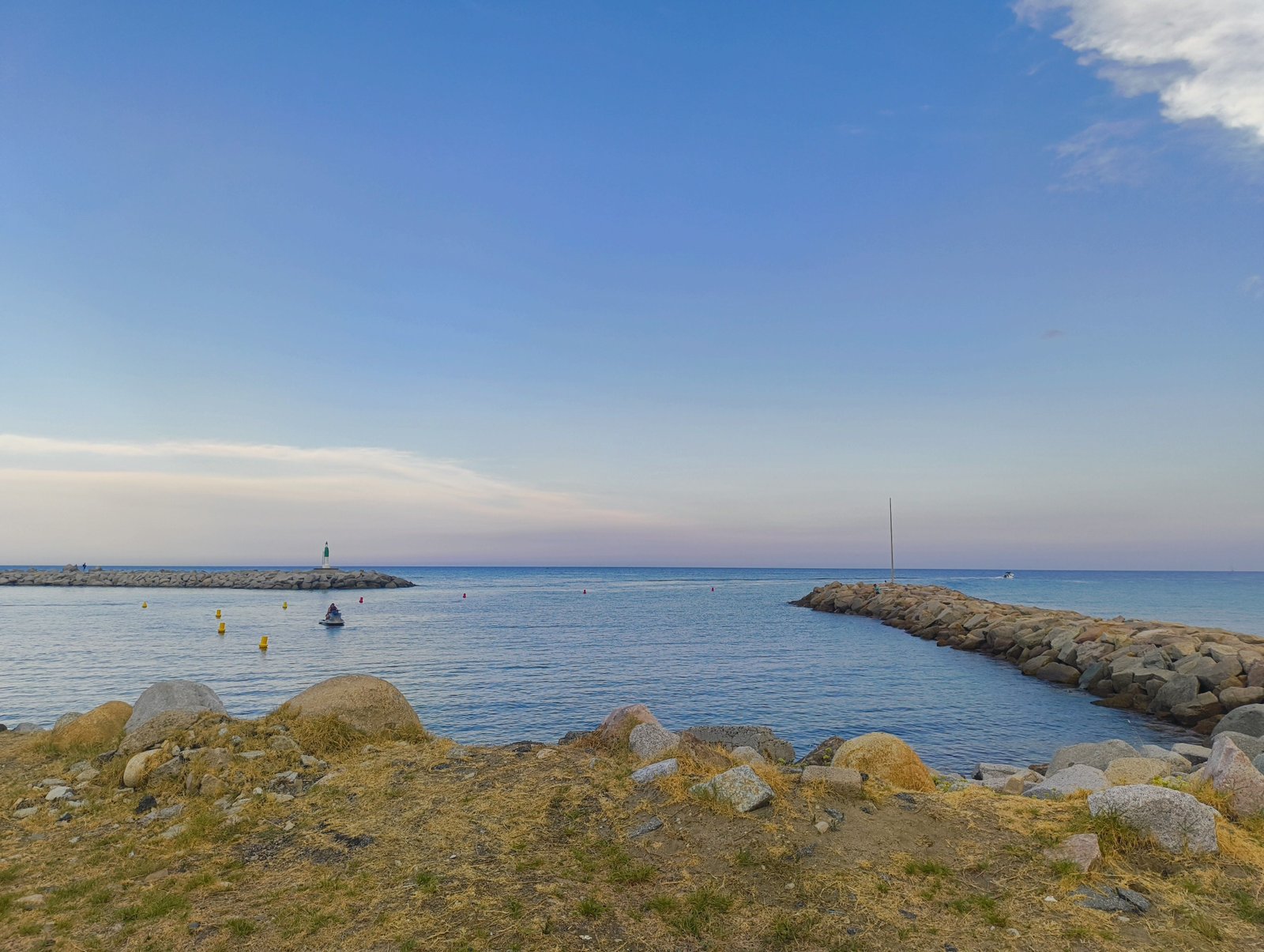 Une entrée de port délimitée par deux jetées de rochers, photo gratuite