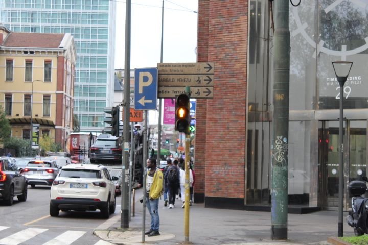 Une scène de rue urbaine en Italie, on y voit des voitures, les panneaux de signalisation et des individus, photo gratuite