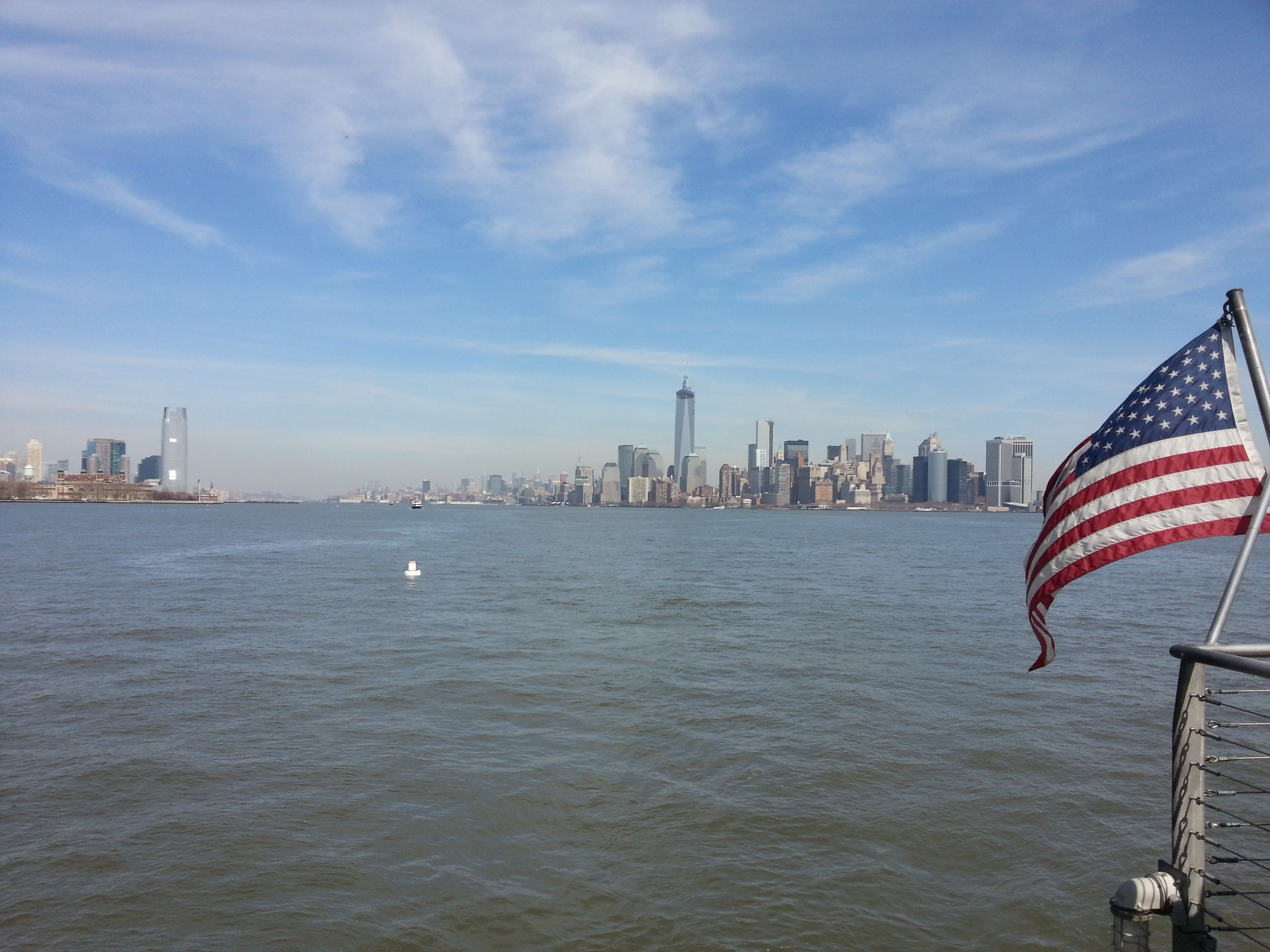 Drapeau américain accroché à un bateau sur le fleuve, vue de loin des immeubles de la ville de New-York, États-Unis, photo gratuite