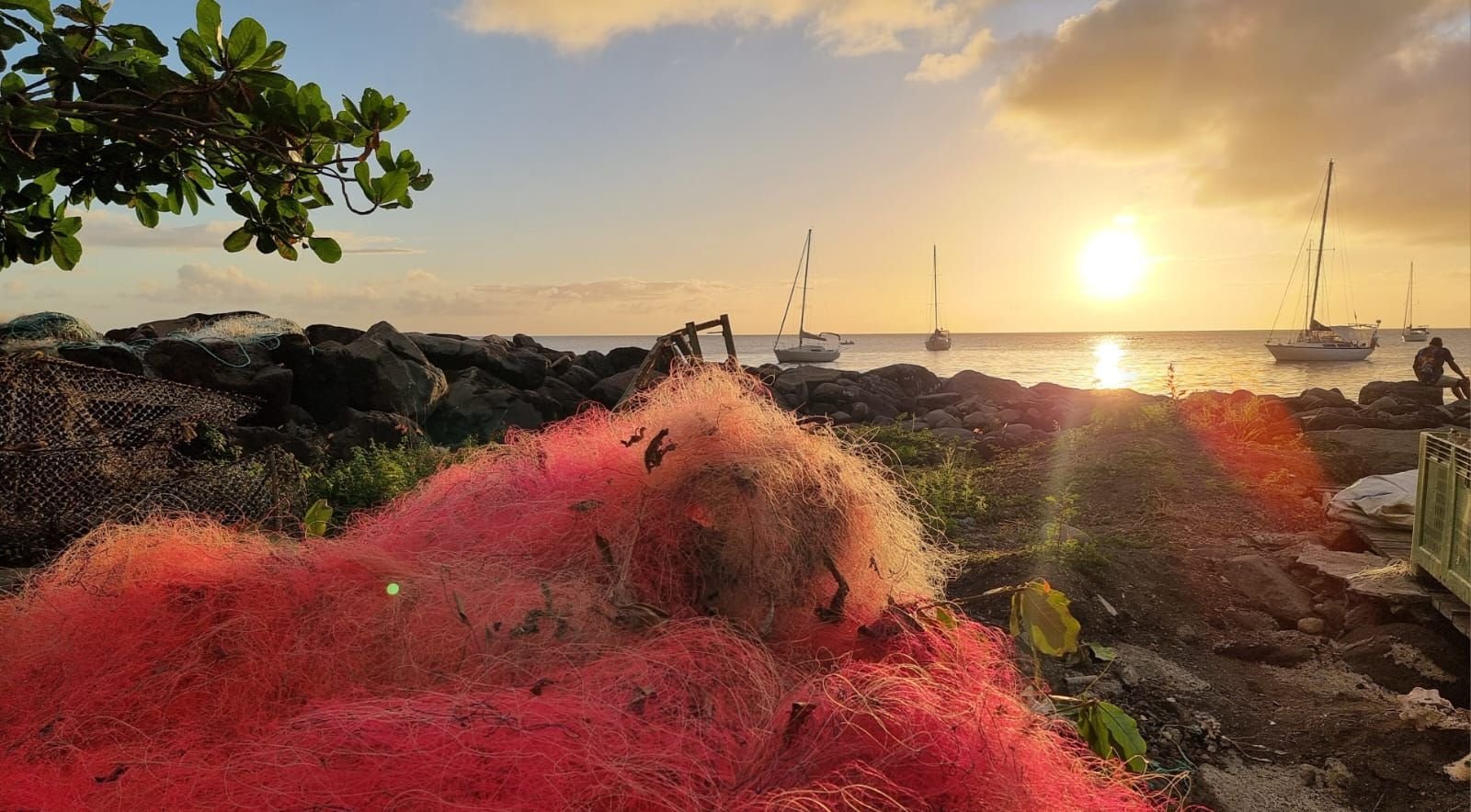 Coucher de soleil sur un port avec un filet de pêche rouge en avant plan photo gratuite