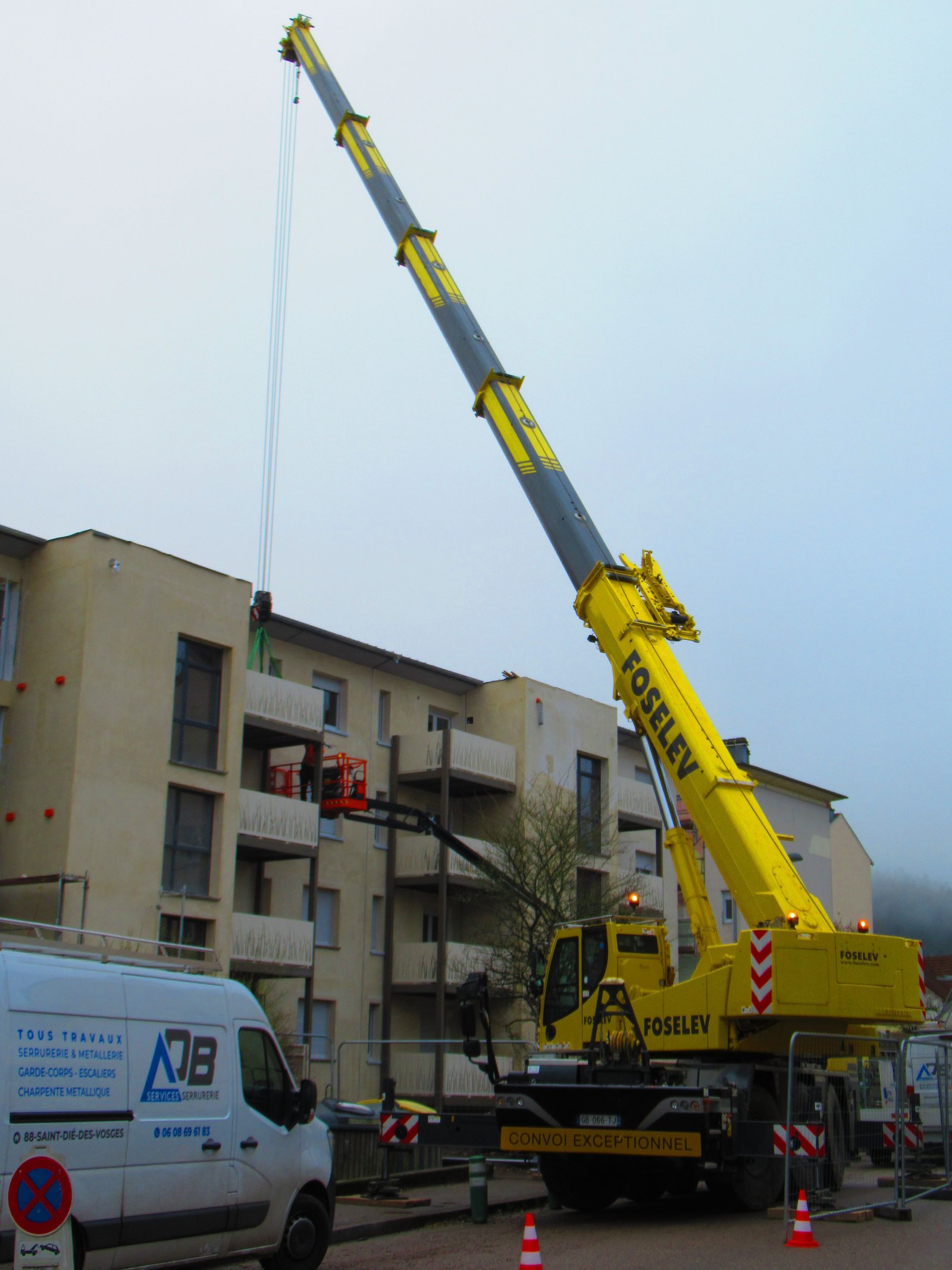 Grue automotrice routière, levage d'objet dans un bâtiment en étage photo gratuite - Selbstfahrender Straßenkran zum Heben eines Objekts in einem mehrstöckigen Gebäude, kostenlose Fotos