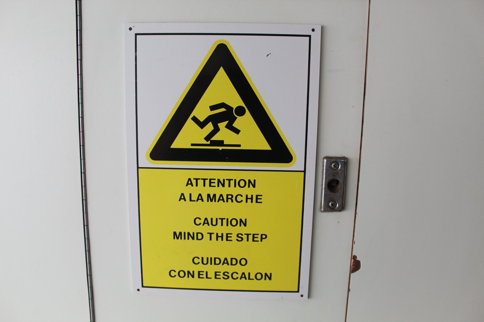 Un panneau d'avertissement de sécurité multilingue indiquant de faire attention à la marche, dans un bateau, photo gratuite