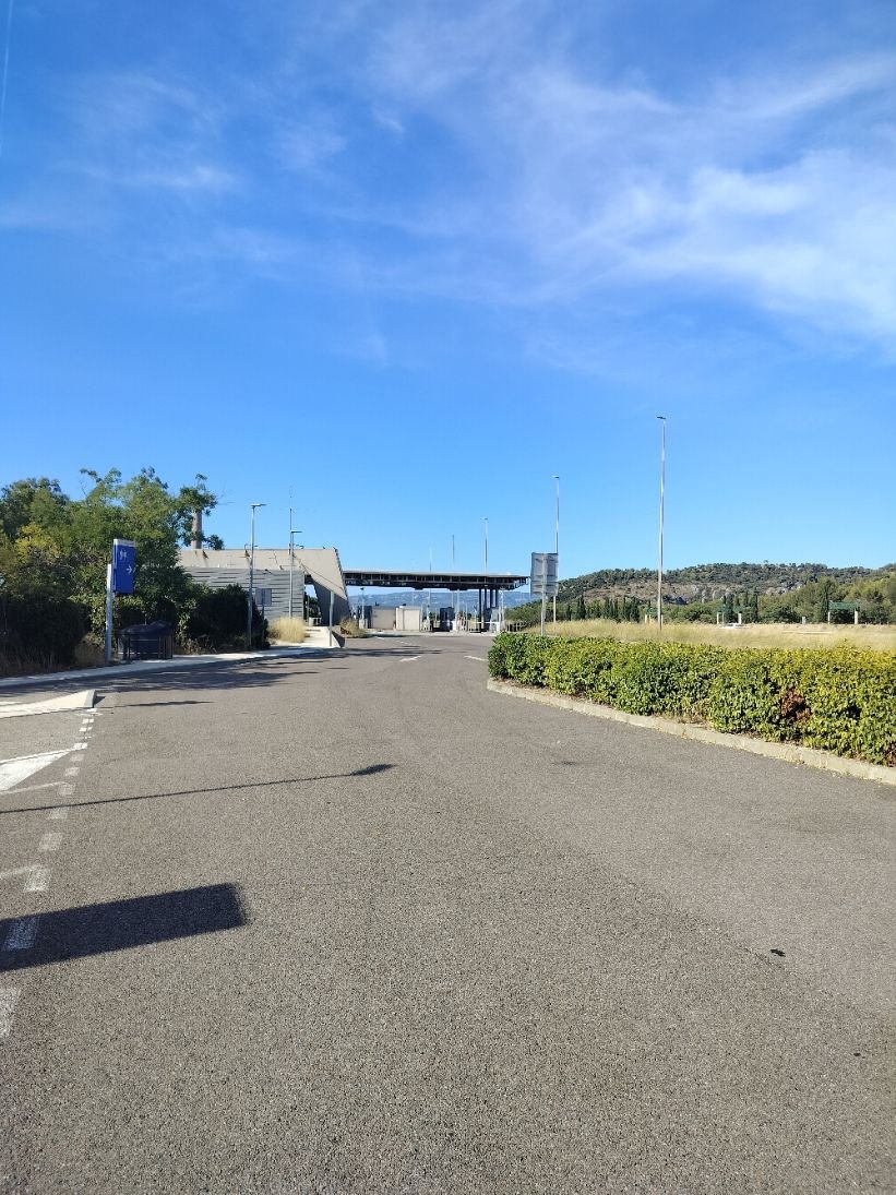 Une route au péage avec un trottoir et de la végétation, photo gratuite