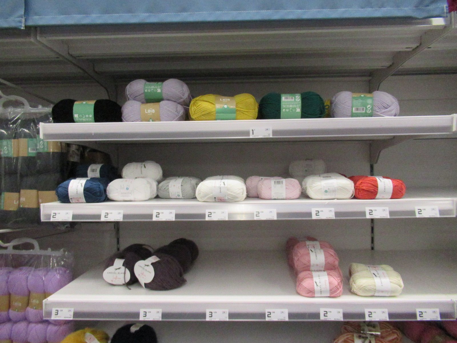 Pelotes de laines multicolores sur les rayons d'un magasin