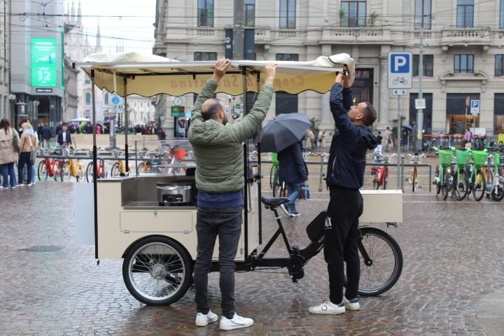Deux personnes devant un vélo-cargo aménagé en stand de nourriture mobile, souvent appelé food bike, photo gratuite