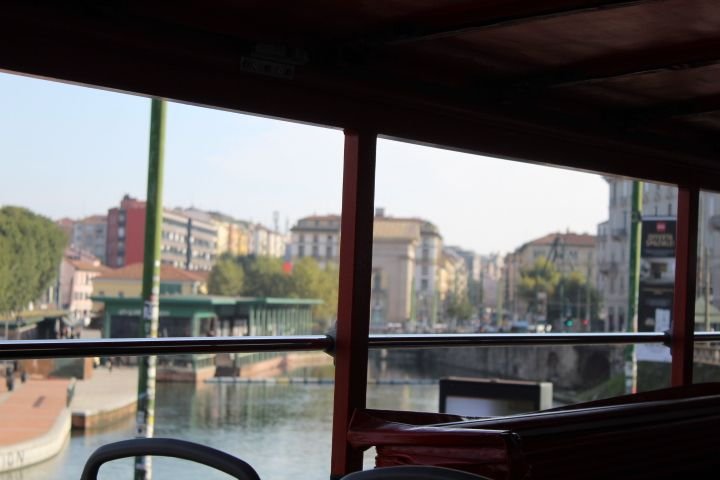 La vue depuis l'intérieur d'un véhicule, offrant une perspective sur une voie navigable bordée de bâtiments et d'une rue animée, photo gratuite