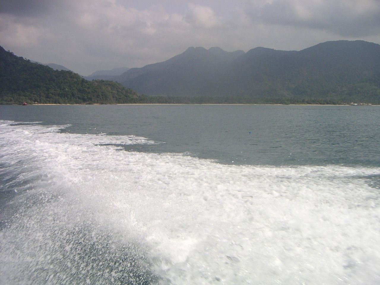 Une scène naturelle avec un plan d'eau montrant la traînée d'un bateau, photo gratuite