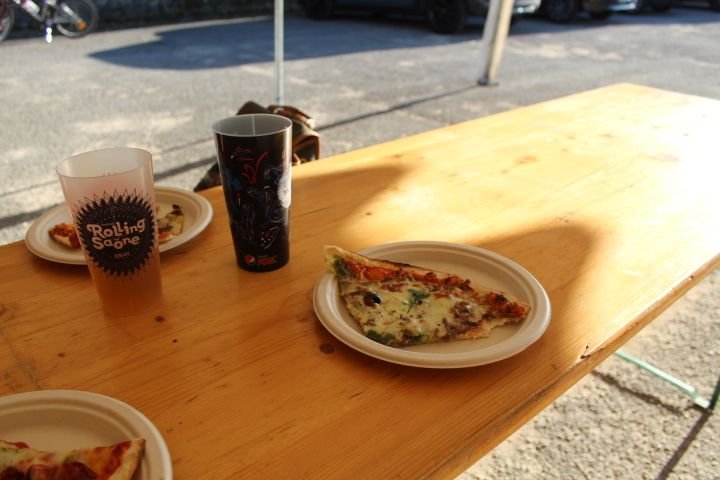 Une table en bois avec plusieurs assiettes contenant des parts de pizza, deux verres, photo gratuite
