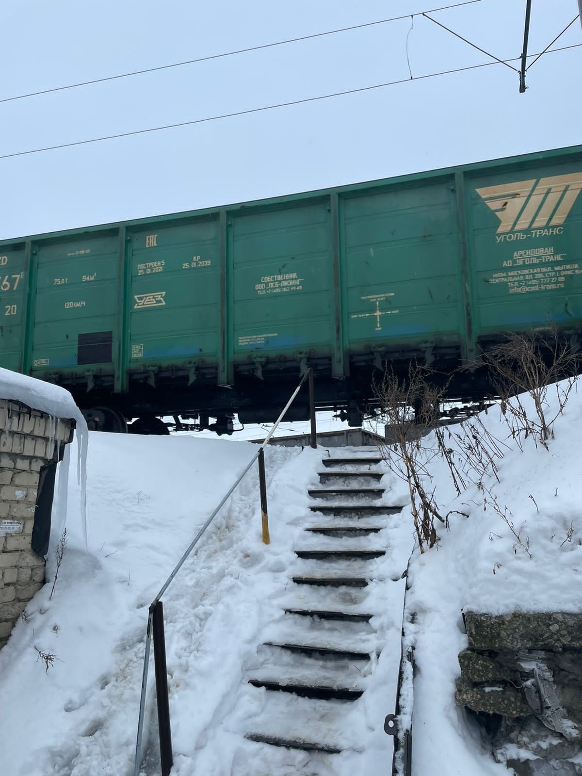 Passage d'un train de marchandise vert sur des rails enneigés photo gratuite