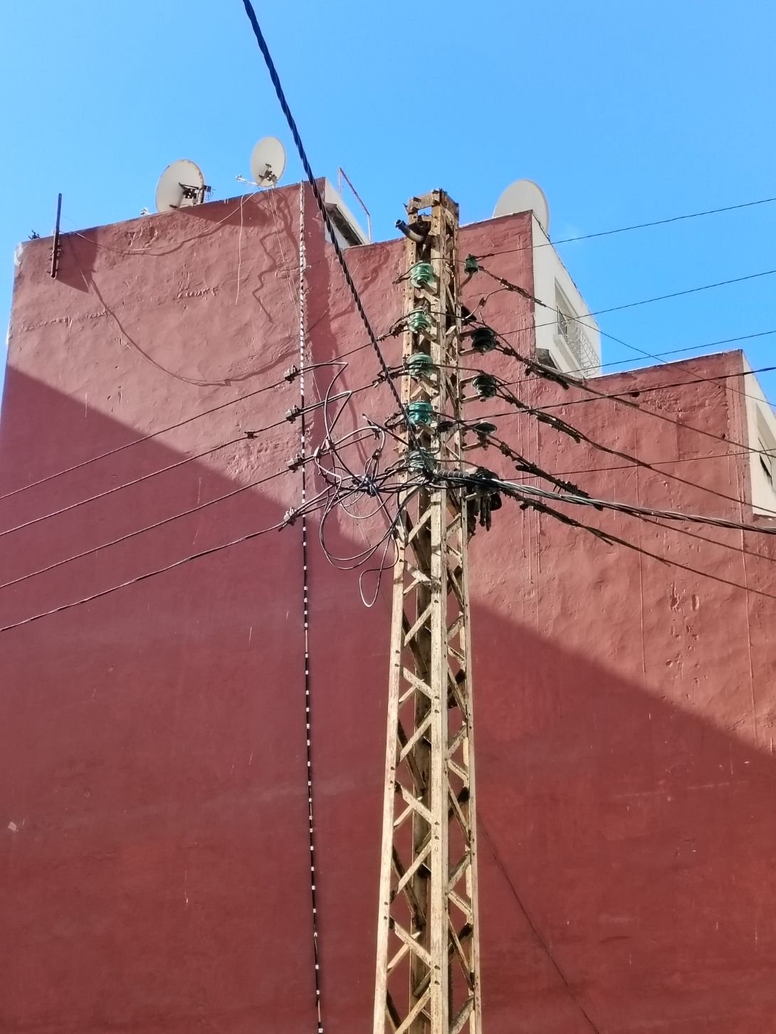 Un poteau électrique en treillis métallique transportant de multiples câbles et fils, photo gratuite