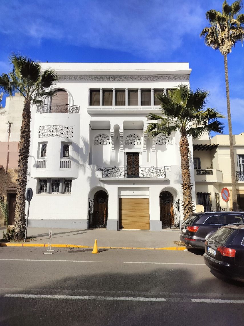 Façade d'un bâtiment blanc, en étage, à quelques mètres du goudron dans la ville de Casablanca au Maroc photo gratuite