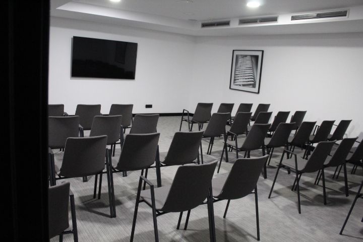 Salle de réunion vide avec un écran et des chaises photo gratuite