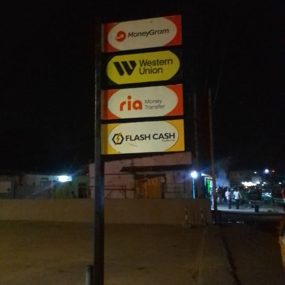 panneau publicitaire indiquant une agence de transfert des fonds via Western Union, Moneygram, Ria et Flash cash photo gratuite