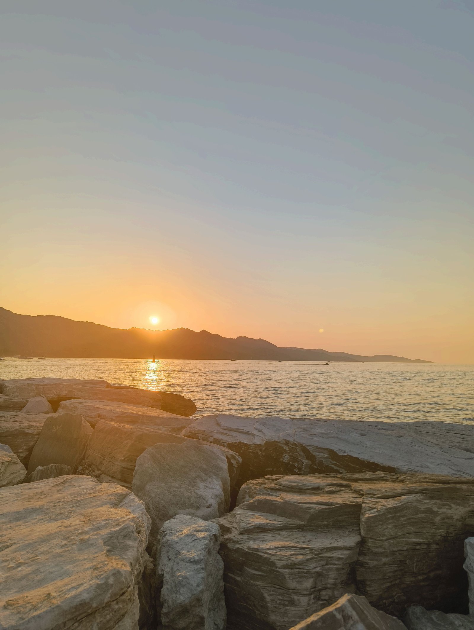 Lever de soleil sur la mer, vu depuis une côte rocheuse, photo gratuite