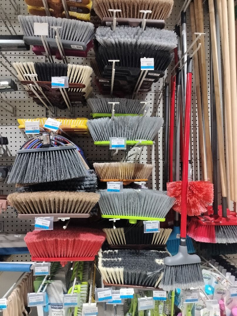 Un assortiment de balais disposés sur un présentoir de magasin, photo gratuite