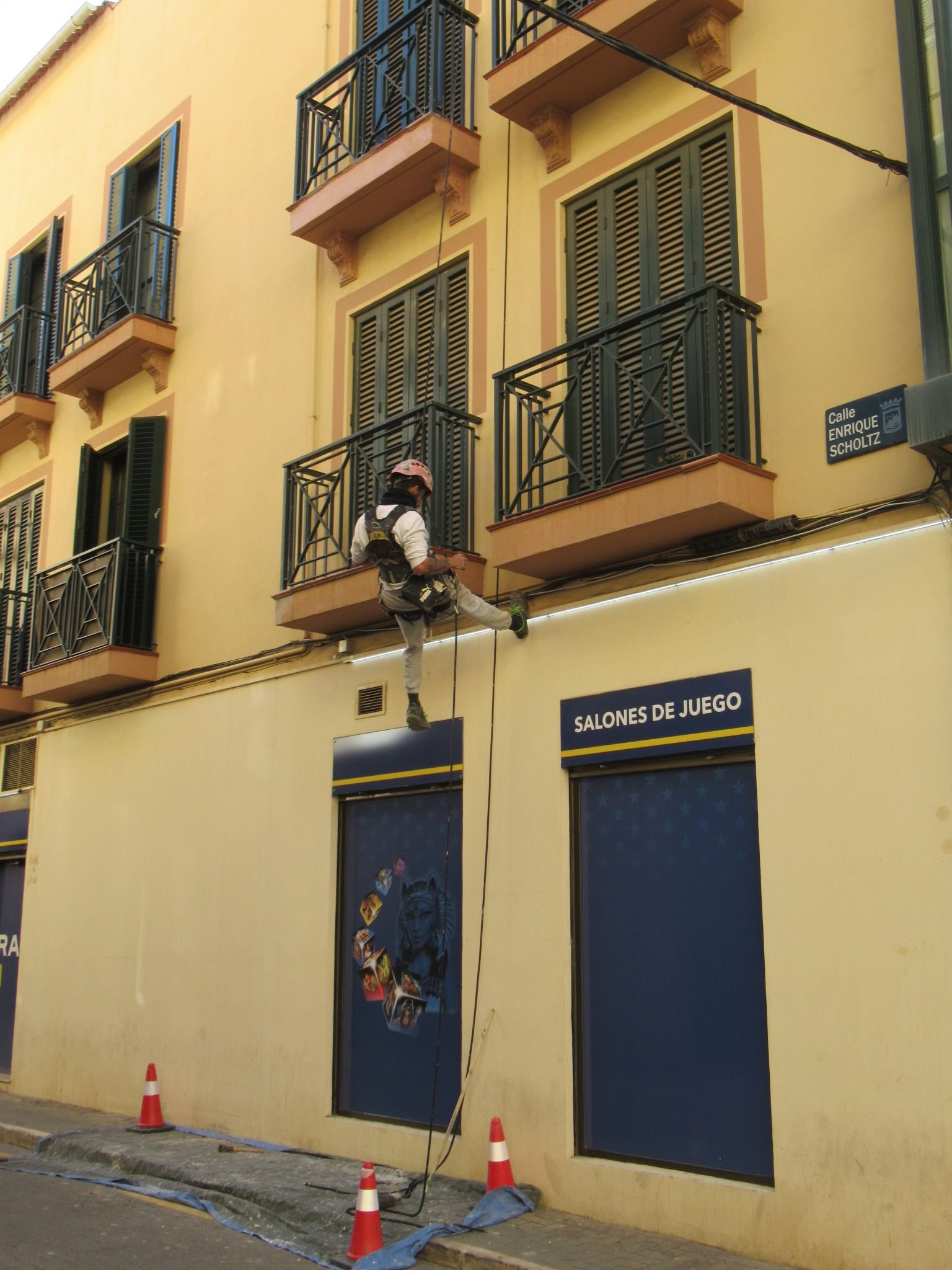 Un ouvrier effectuant des travaux en hauteur sur une façade à Malaga, photo gratuite