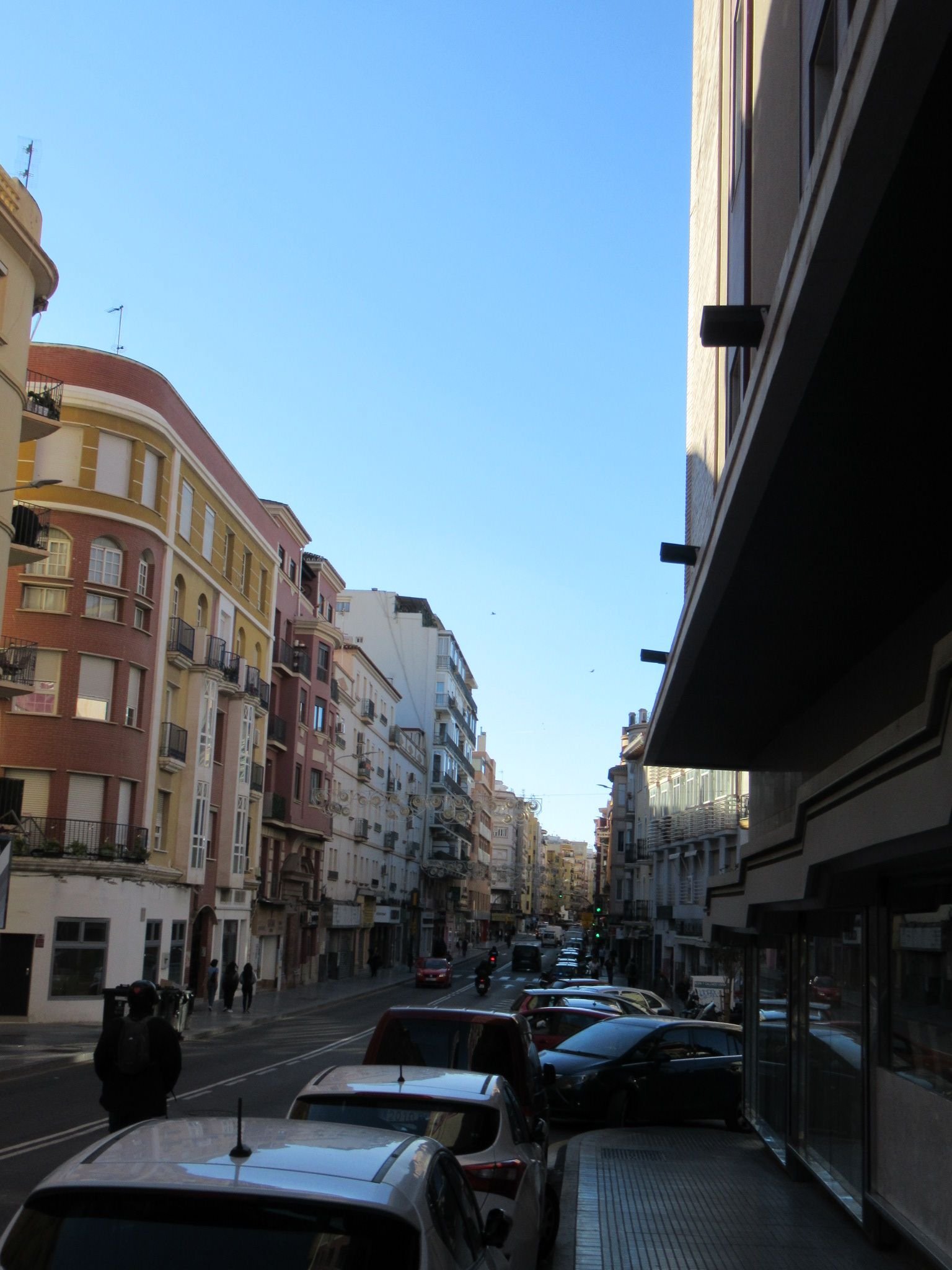 Une ruelle de Malaga avec des bâtiments et des voitures, photo gratuite