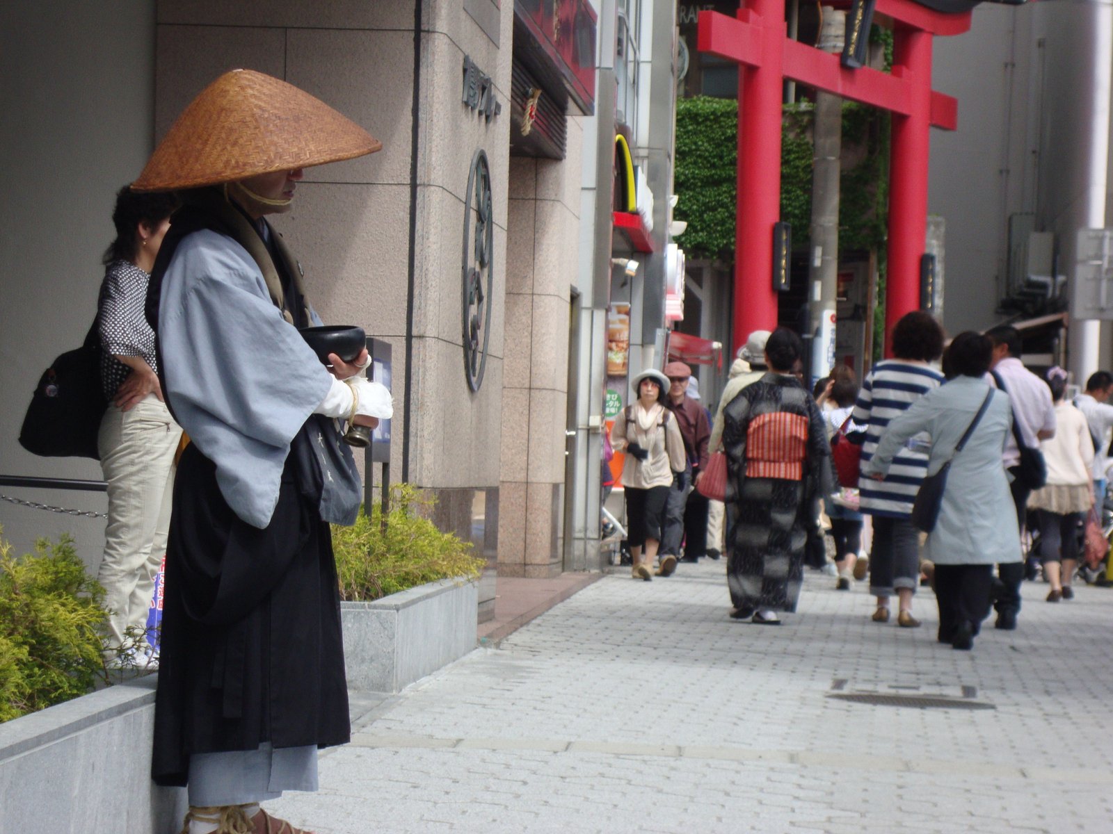 Passants en tenue traditionnelle du Japon devant un Torii rouge photo gratuite