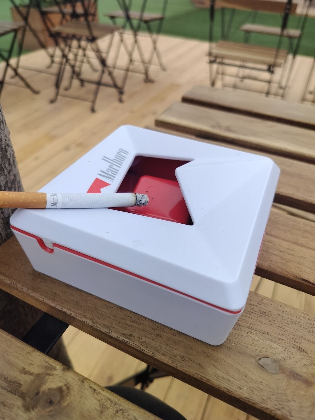 Un cendrier de la marque Marlboro, avec une cigarette Marlboro posée dessus, photo gratuite