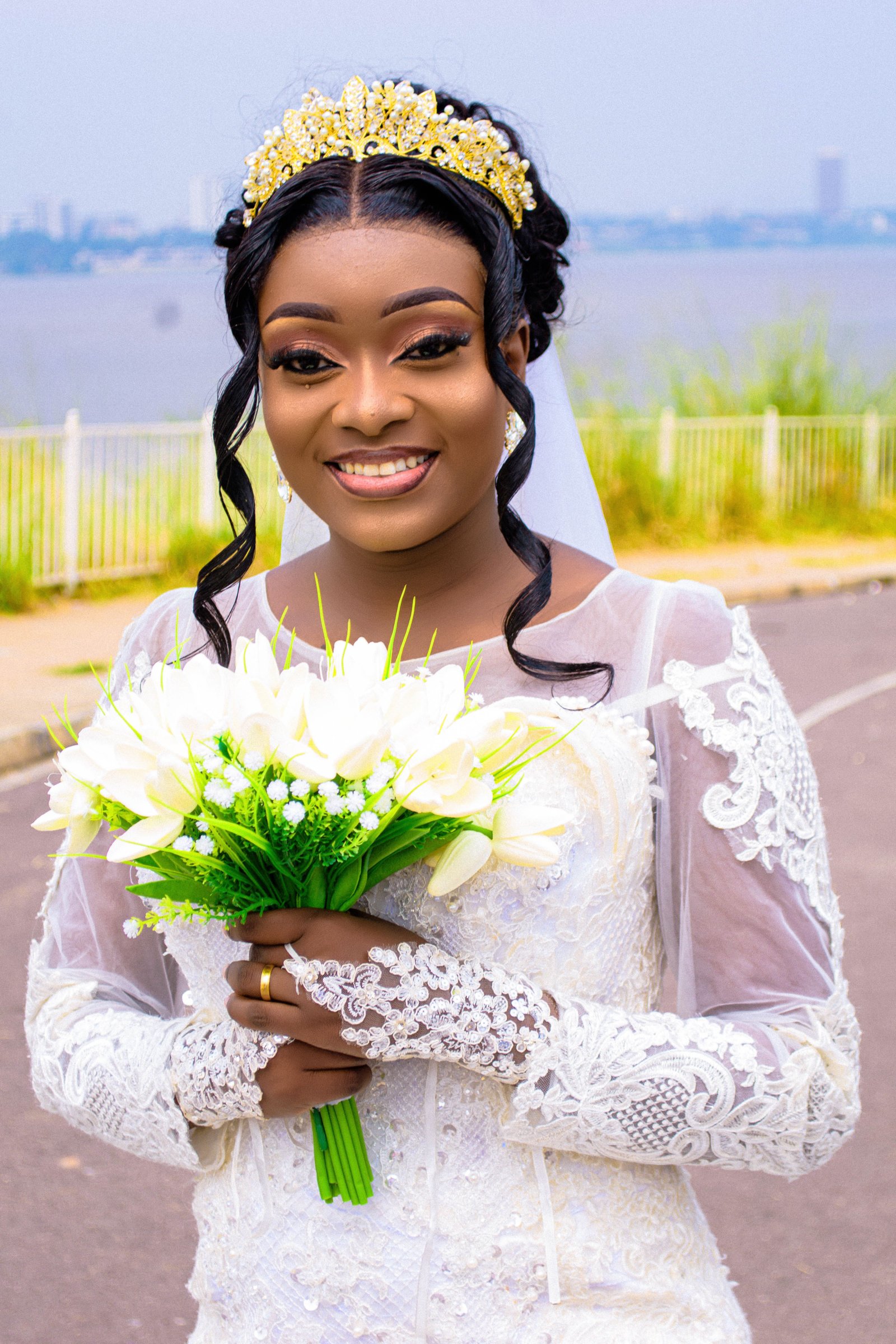 Portrait de mariée souriante en robe blanche avec couronne dorée et bouquet de fleurs blanches photo gratuite photo gratuite