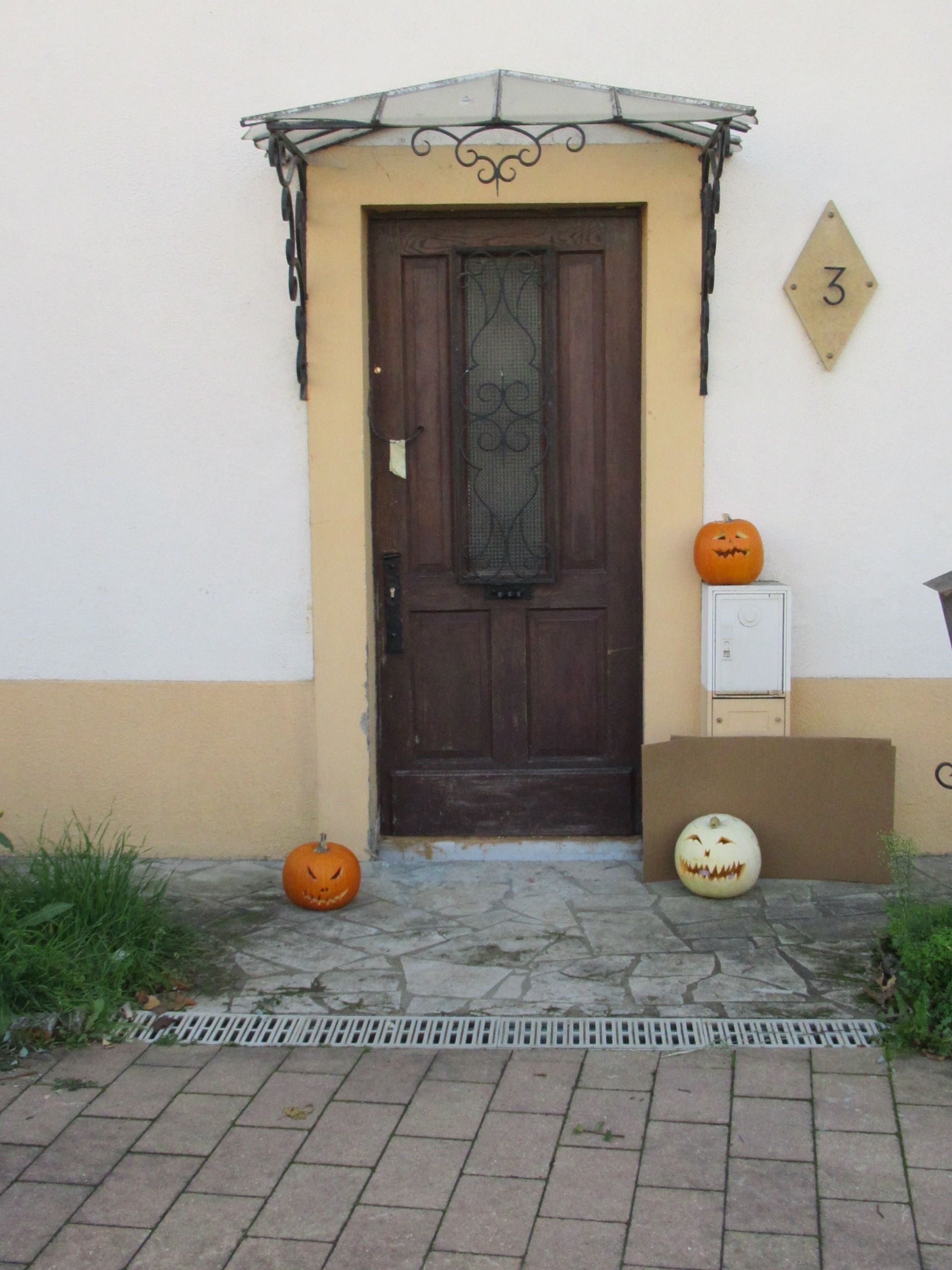 Façade d'une porte d'entrée avec marquise en verre citrouilles