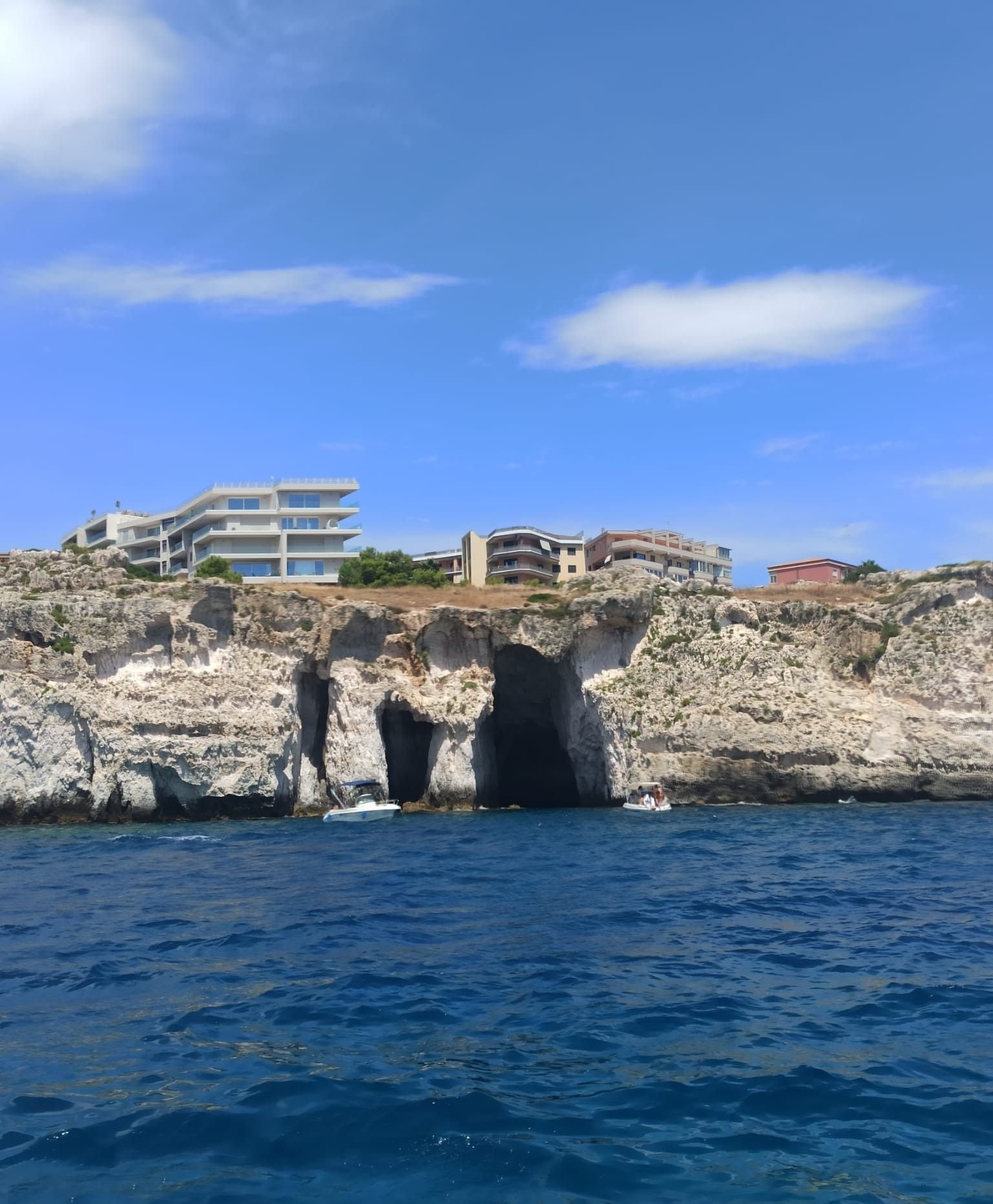 La côte d'Ortigia, l'île de Sicile, Italie, avec ses falaises, ses grottes marines et des bâtiments construits au sommet, photo gratuite