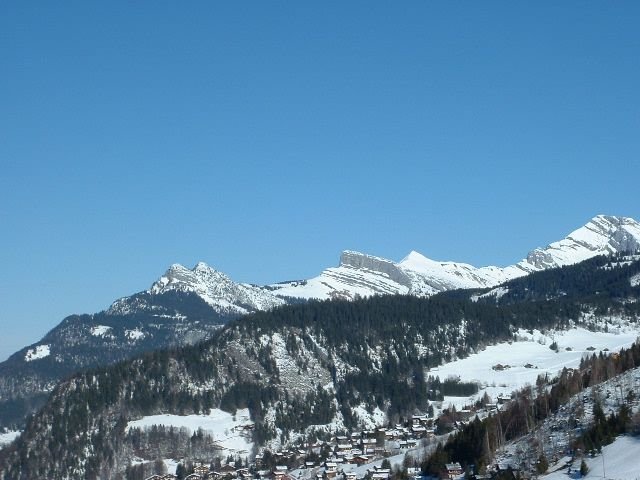 Chalets et cimes sous le ciel alpin photo gratuite