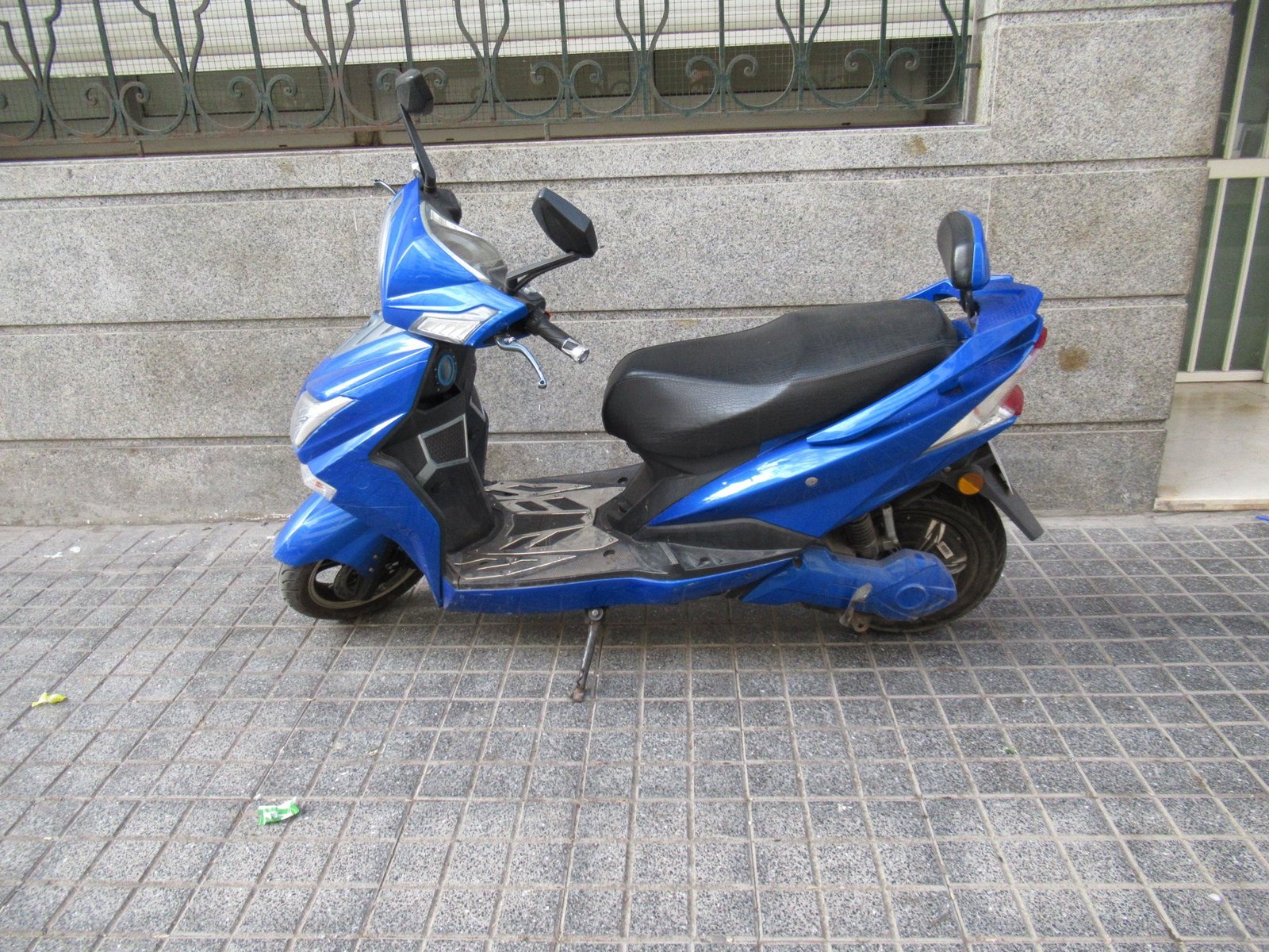 Scooter électrique Sunra Hawk garé sur un trottoir photo gratuite