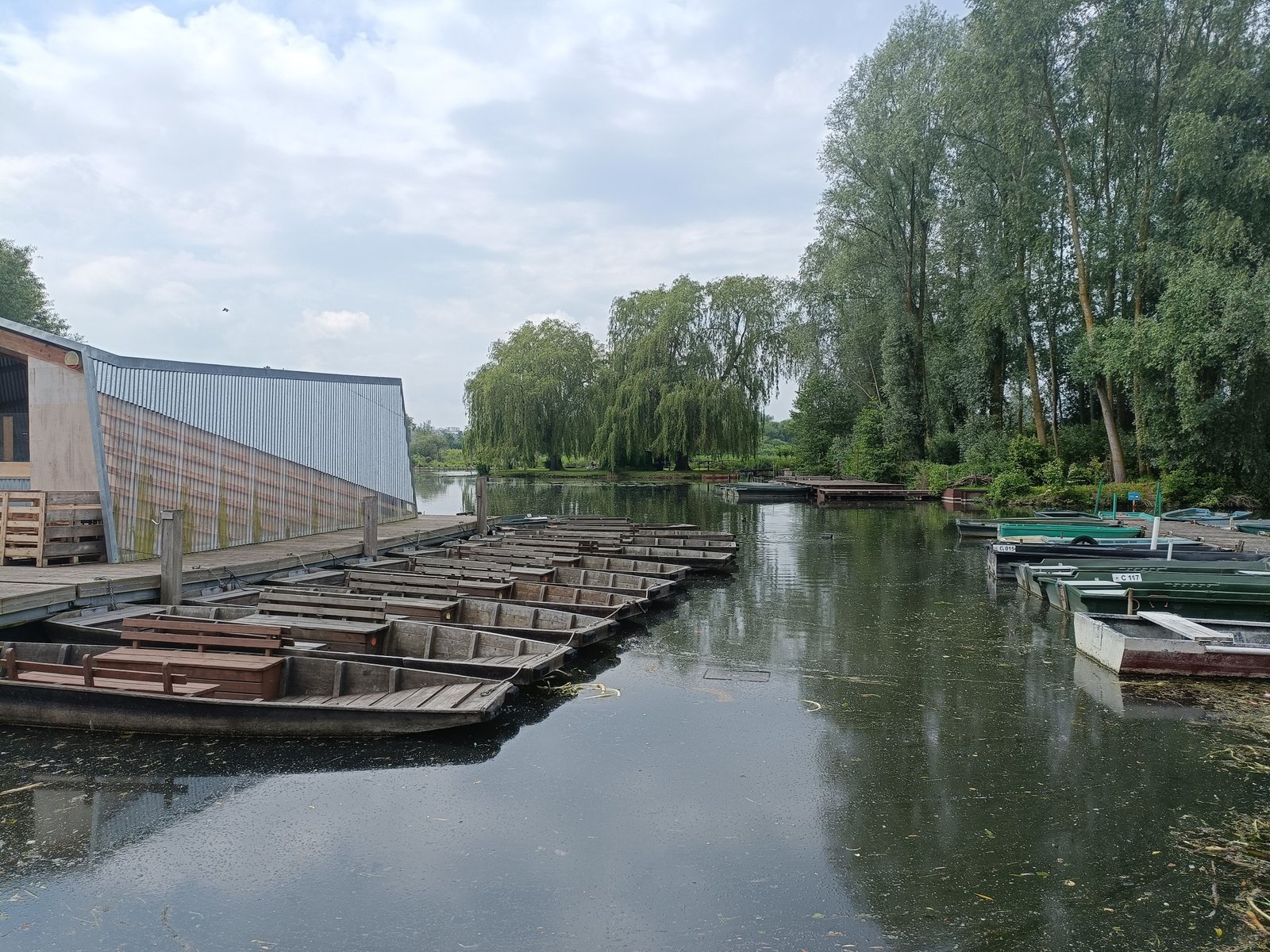 Des bateaux traditionnels, des barques à fond plat, amarrés le long d'un quai en bois, photo gratuite