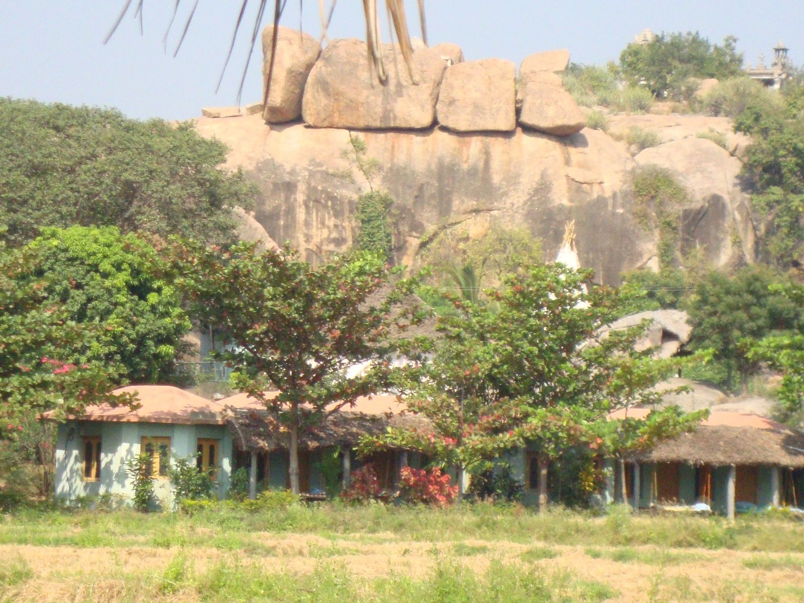 Un paysage à Hampi, batiment en dessous d'une formation rocheuse, photo gratuite