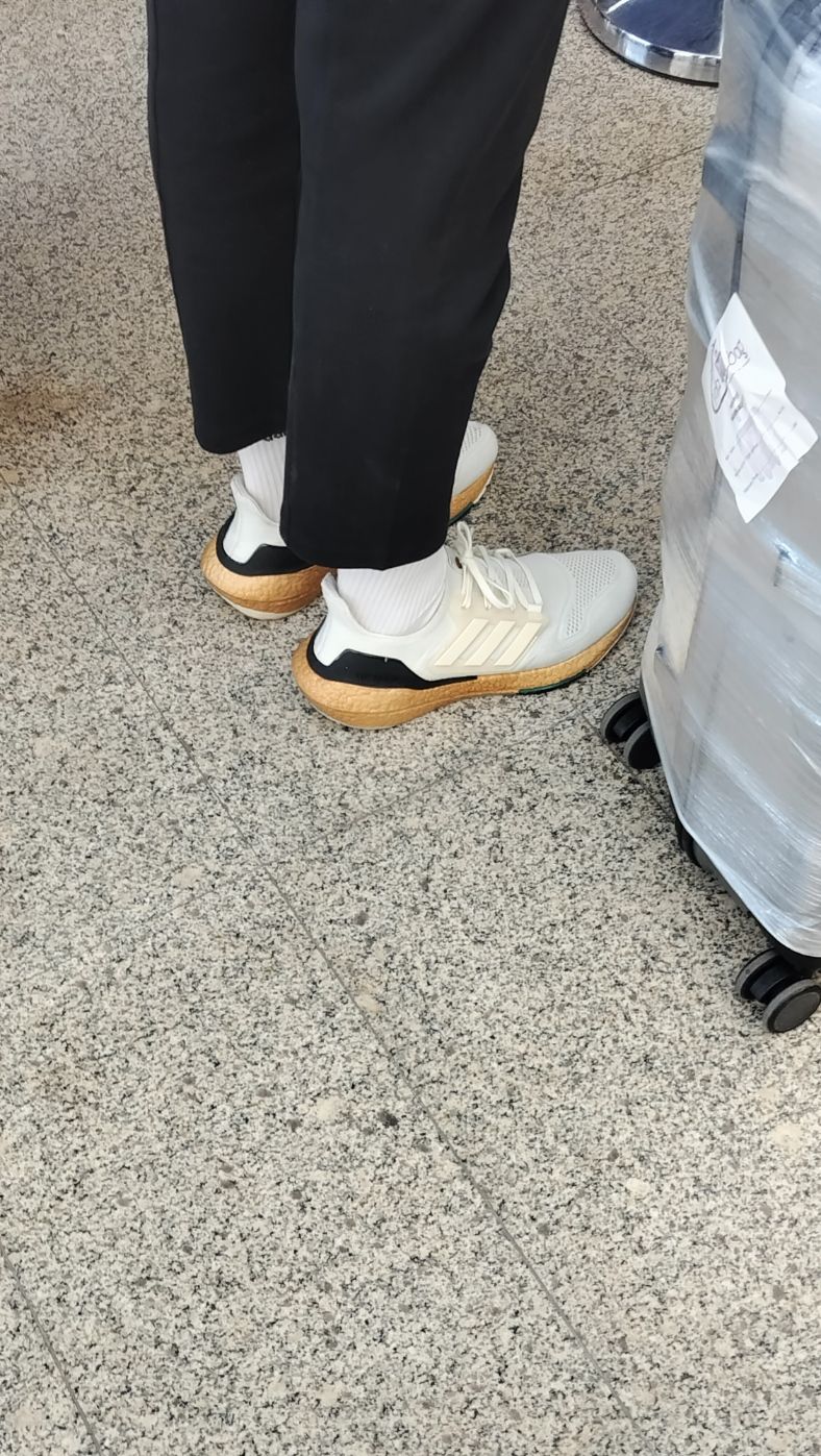 Personne portant une paire de baskets blanches