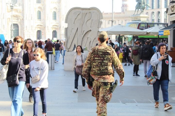 Un soldat de l'armée italienne se promène dans la ville, au milieu des civils, photo gratuite
