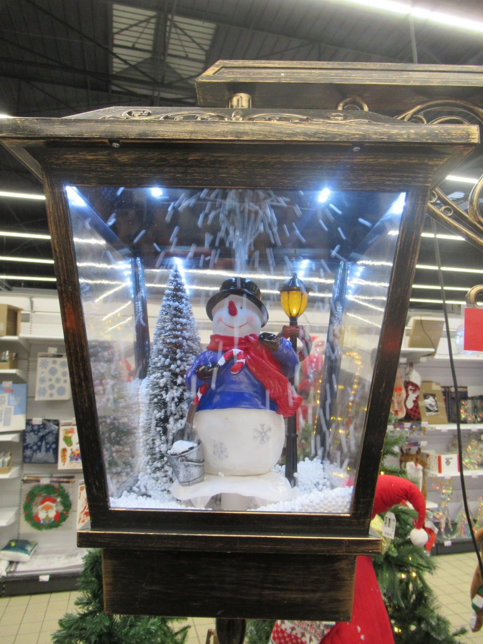 Une lanterne de Noël décorative avec un bonhomme de neige et un effet de chute de neige artificielle, photo gratuite