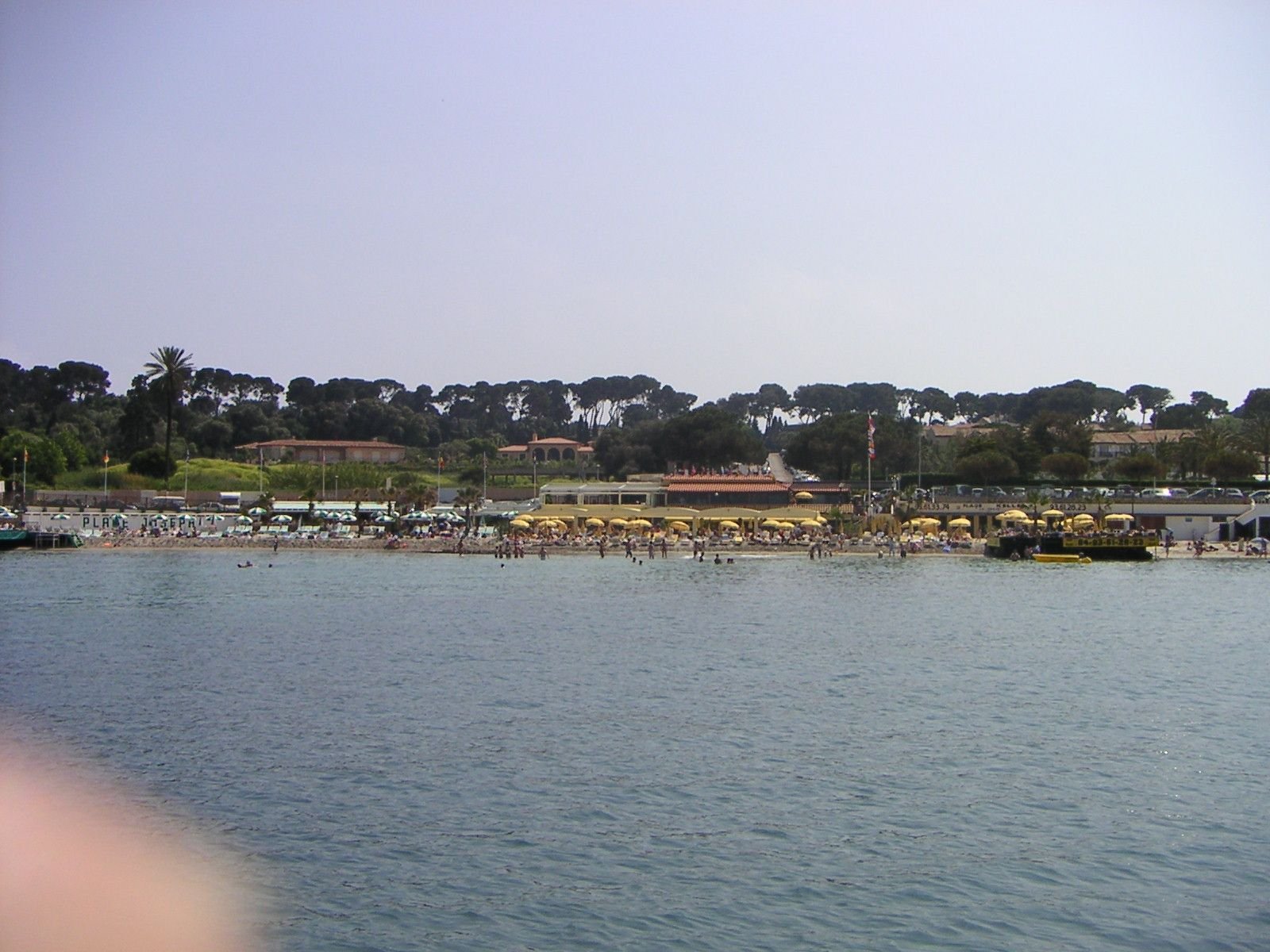 Une plage animée, des parasols jaunes sont visibles sur la plage, indiquant une activité balnéaire, photo gratuite