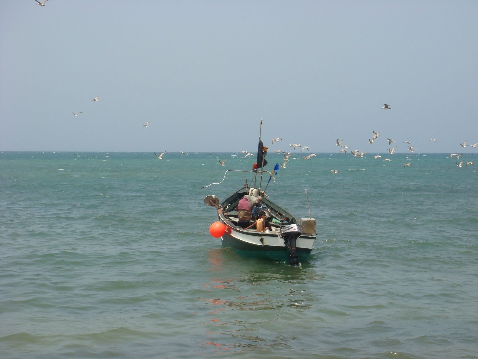 bateau de pêche en mer équipé de matériel de pêche et d’un moteur hors-bord photo gratuite