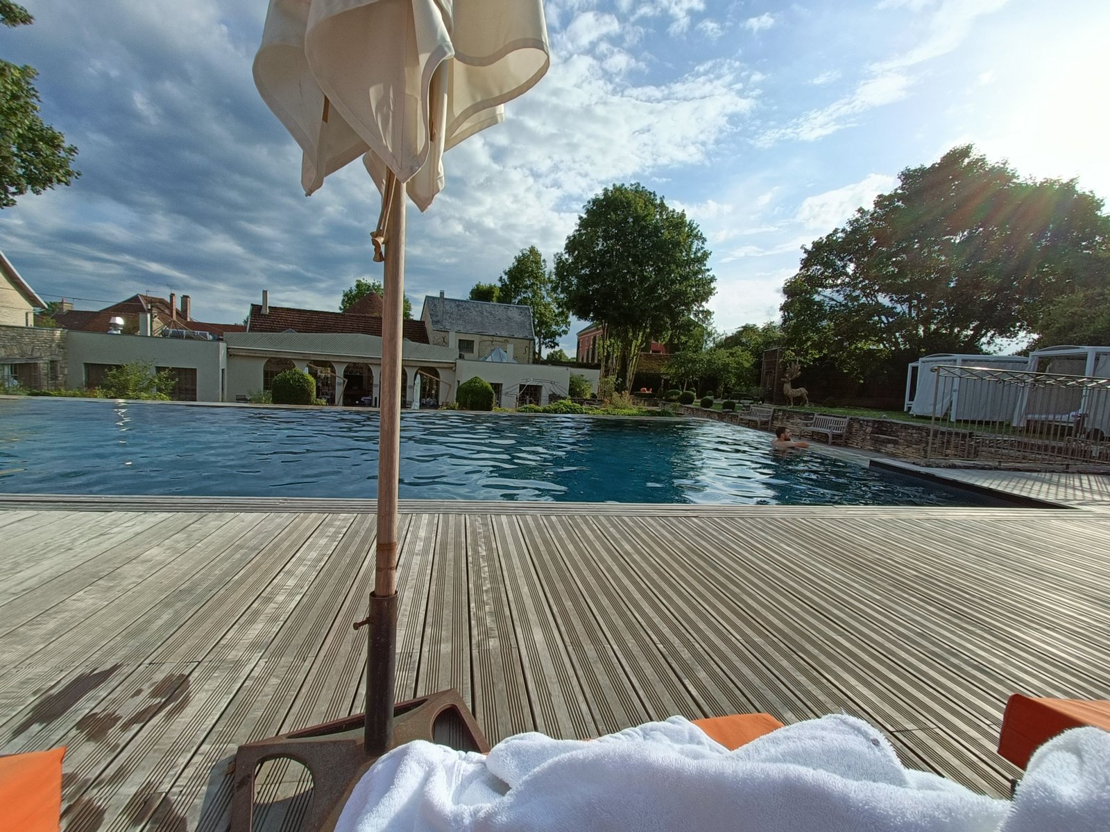 Une piscine avec une terrasse en bois, photo gratuite