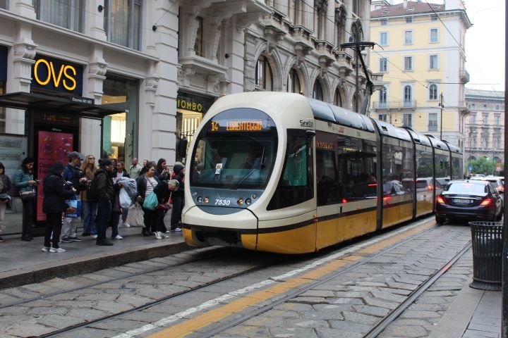Tramway électrique en déplacement dans la ville de Milan, on observe des personnes devant le magasin OVS, prêt à embarquer, photo gratuite