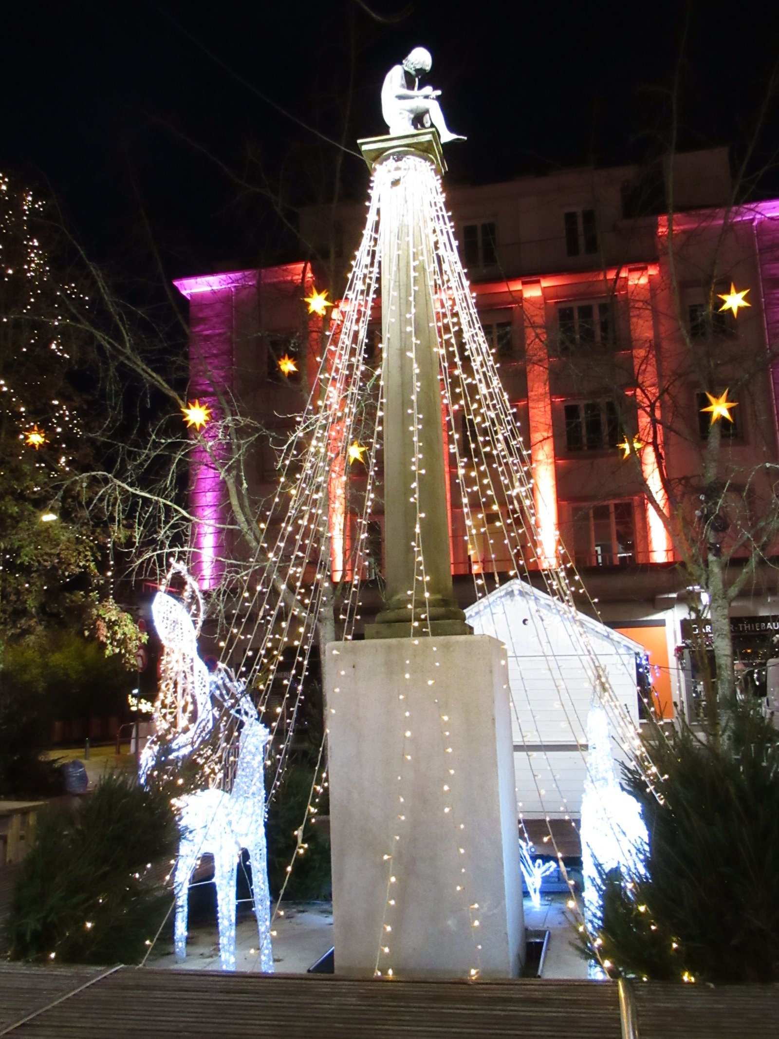 Illuminations de Noël autour de la colonne de l’enfant lecteur photo gratuite