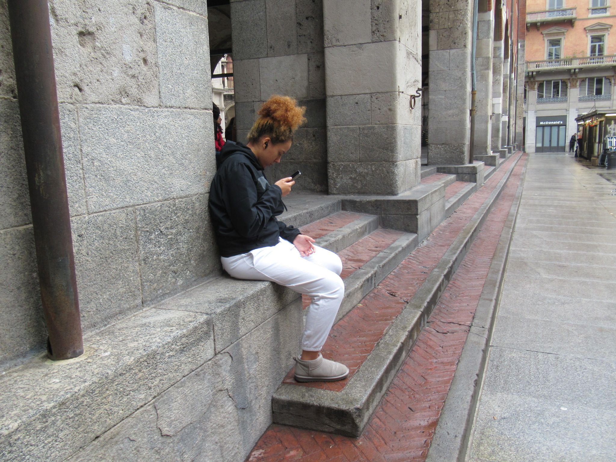 Jeune femme brune assise sur des marches avec son téléphone photo gratuite