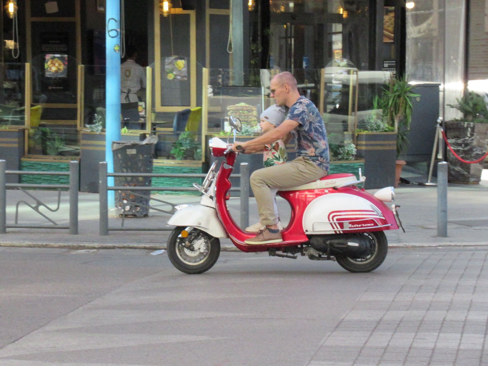 Homme roulant sur un scooter à moteur rouge et blanc