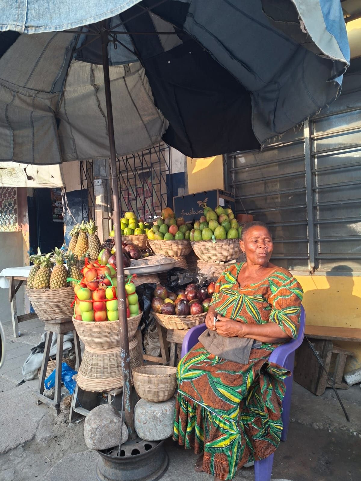 Marchande assise à côté de son étal à Lomé au Togo, photo gratuite