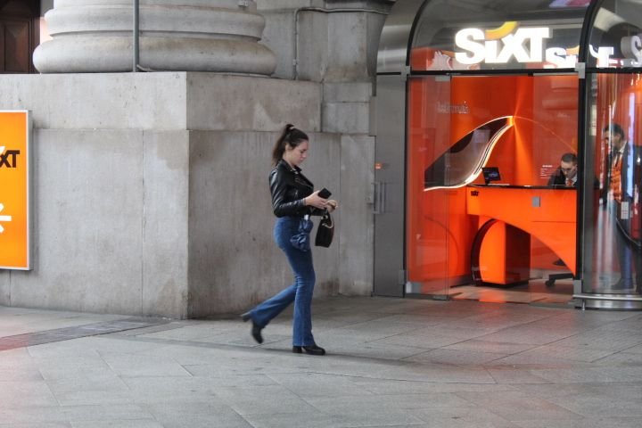 D'une femme  devant une agence de location de voitures Sixt photo gratuite