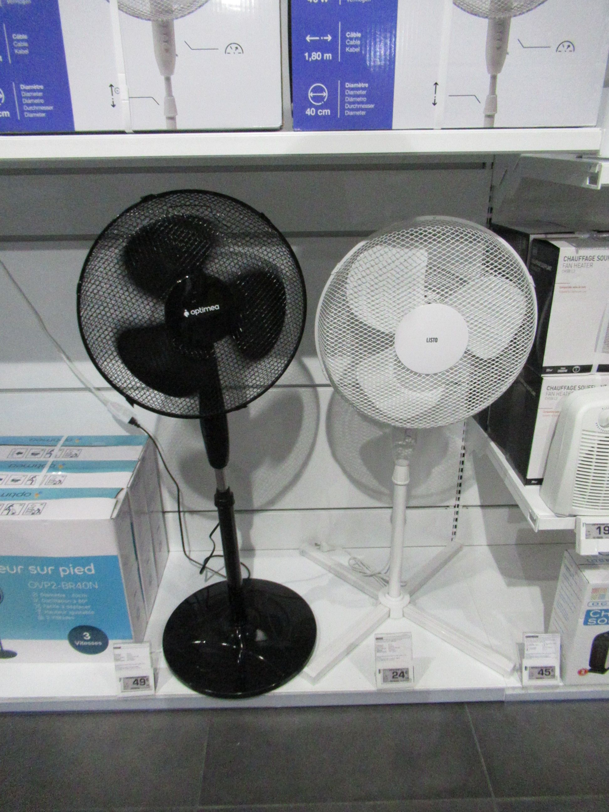Deux ventilateurs noir et blanc sur sur pieds dans un magasin